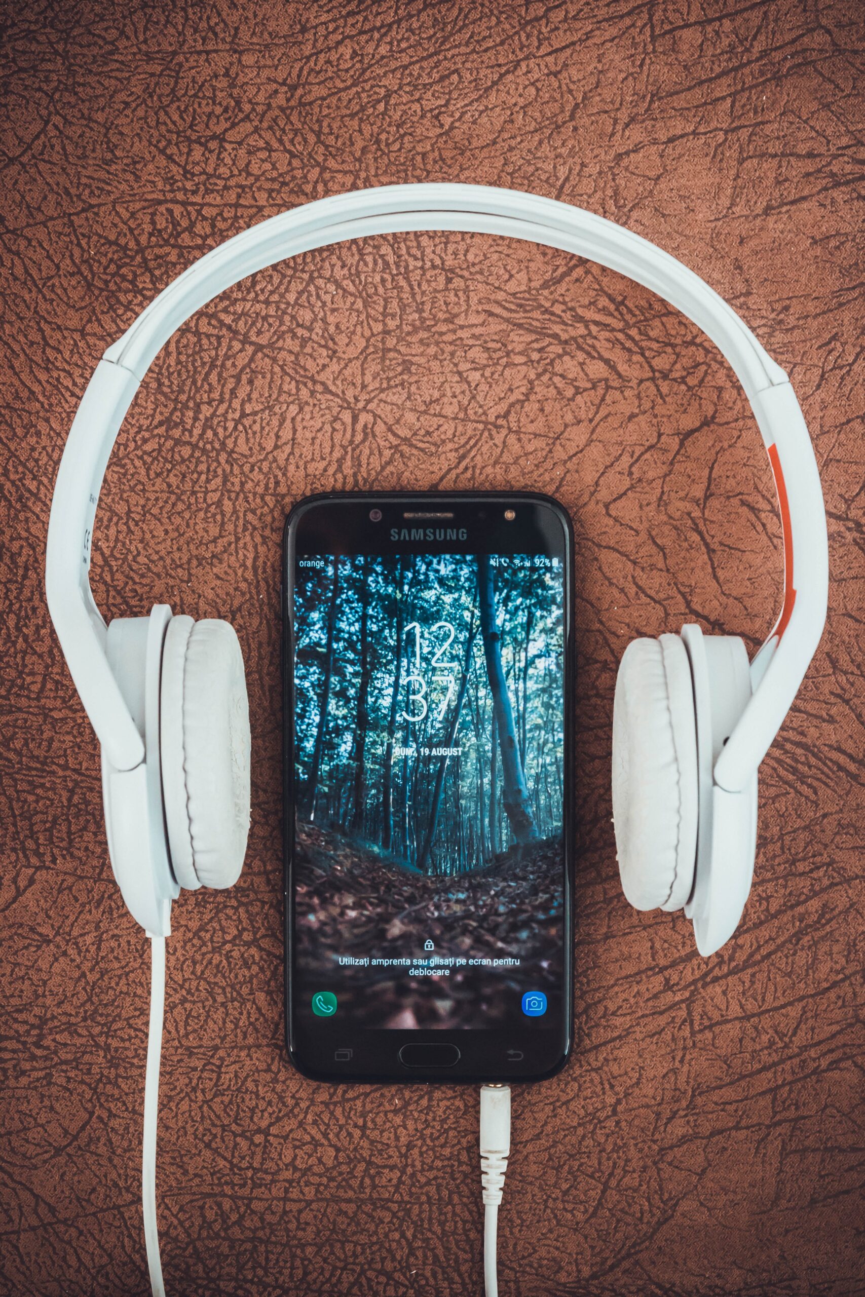 turned-on-black-samsung-smartphone-between-headphones-1337753